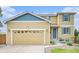 Charming home featuring a two-car garage, well-kept lawn, and a welcoming entrance with blue accents at 828 Lehigh Cir, Erie, CO 80516