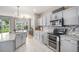 Well-equipped kitchen with stainless steel appliances and stylish backsplash, seamlessly connecting to dining area at 828 Lehigh Cir, Erie, CO 80516