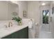 Bathroom with a vanity with green cabinets, white countertops, and a large mirror at 2635 S Lamar Way, Lakewood, CO 80227