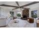 Inviting living room featuring a stone fireplace, beamed ceilings, and ample natural light at 2635 S Lamar Way, Lakewood, CO 80227