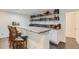Custom bar with stone counters, bar seating, and ample liquor storage at 149 Jewel St, Brighton, CO 80603