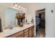 Well-lit bathroom featuring double sinks, a large mirror, and a walk-in closet at 149 Jewel St, Brighton, CO 80603