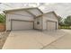 Spacious three-car garage with neutral doors and concrete driveway, providing ample parking at 149 Jewel St, Brighton, CO 80603