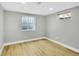 Basement bedroom with natural light from 2 windows, and light hardwood floors at 7634 Navajo St, Denver, CO 80221
