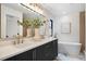 Modern bathroom featuring double vanity, a soaking tub, and a large mirror at 3049 S Cherokee St, Englewood, CO 80110