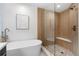 Bright bathroom with soaking tub and glass enclosed shower with bench seating at 3049 S Cherokee St, Englewood, CO 80110