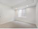 Bright bedroom featuring neutral carpet, white walls, and a window allowing natural light at 3049 S Cherokee St, Englewood, CO 80110