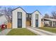 Striking modern home with black framed windows, white stucco, and a well manicured lawn with stone accents at 3049 S Cherokee St, Englewood, CO 80110