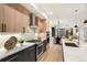 Modern kitchen with stainless steel appliances, custom cabinetry, large island and open dining area at 3049 S Cherokee St, Englewood, CO 80110