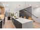Bright, open kitchen featuring a large island with seating, hardwood floors and modern lighting at 3049 S Cherokee St, Englewood, CO 80110