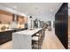 Modern kitchen with large island, bar stools, hardwood floors, stainless steel appliances and open to living space at 3049 S Cherokee St, Englewood, CO 80110