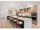A modern kitchen with an island, quartz countertops, and wood cabinets, offering a luxurious culinary experience at 3049 S Cherokee St, Englewood, CO 80110