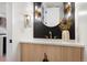 Elegant powder room with wood vanity, gold accents, stylish lighting, and dark backsplash at 3049 S Cherokee St, Englewood, CO 80110