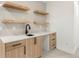 Basement wet bar features a sink, cabinets, drawers, and open shelves at 3049 S Cherokee St, Englewood, CO 80110