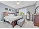 Comfortable bedroom with a plush carpet, a bed with decorative pillows and covers, and bright window light at 19771 E Wesley Pl, Aurora, CO 80013