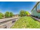 Landscaped front yard featuring a green lawn and retaining wall alongside the street with mature trees in the background at 19771 E Wesley Pl, Aurora, CO 80013