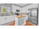 Kitchen featuring white cabinets, stainless appliances, kitchen island, and tile flooring at 19771 E Wesley Pl, Aurora, CO 80013