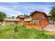 The backyard features a large, well-maintained lawn, a wood fence, and mature trees, perfect for outdoor activities at 1255 S Dillon Way, Aurora, CO 80012