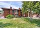 Exterior shot of the property featuring a well-manicured lawn and mature shade trees at 1255 S Dillon Way, Aurora, CO 80012