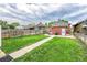 Green backyard featuring a brick home with a well-kept lawn and a storage shed at 2204 S Acoma St, Denver, CO 80223