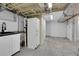 Unfinished basement area with kitchenette, additional storage cabinets, and bedroom access at 2204 S Acoma St, Denver, CO 80223