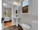 Bathroom featuring a pedestal sink, toilet, and tiled floors, next to the bedroom at 2204 S Acoma St, Denver, CO 80223