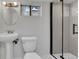 Bright bathroom with a pedestal sink, modern shower and frosted window at 2204 S Acoma St, Denver, CO 80223