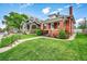 Lovely single-Gathering home featuring brick accents, a covered porch, and a green lawn at 2204 S Acoma St, Denver, CO 80223