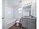 Well-lit bathroom featuring a tub with shower, granite countertops, and gray cabinets at 46526 Avery Ln, Bennett, CO 80102