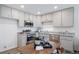 A modern kitchen features gray cabinets, stainless steel appliances, granite countertops, and an adjacent dining table at 46526 Avery Ln, Bennett, CO 80102