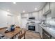 Bright kitchen boasts gray cabinets, stainless steel appliances, granite countertops, and an adjacent dining table at 46526 Avery Ln, Bennett, CO 80102
