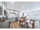 An open concept living area includes a dining table, modern kitchen, and cozy seating arrangement at 46526 Avery Ln, Bennett, CO 80102