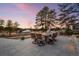 Outdoor dining area with seating for eight, mature trees, and a built-in barbecue at 6001 Powell Rds, Parker, CO 80134