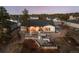 Aerial view of luxurious backyard with patio, hot tub, outdoor kitchen, and dining area with exterior fireplace at 6001 Powell Rds, Parker, CO 80134