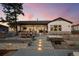 Exterior of a home with a stone patio featuring dining, hot tub, & seamless indoor-outdoor living at 6001 Powell Rds, Parker, CO 80134