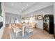 Bright dining room featuring a wooden table, modern chandelier, decorative wall art, and large windows at 6001 Powell Rds, Parker, CO 80134