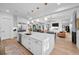 Open kitchen with white cabinets, marble island, stainless steel appliances, and pendant lighting overlooking the living space at 6001 Powell Rd, Parker, CO 80134