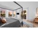 Inviting bedroom with a four-poster bed, large windows providing sunset views, and access to the balcony at 6001 Powell Rds, Parker, CO 80134
