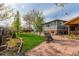 Expansive backyard with a lawn, patio, mature trees, and custom outdoor building at 1313 Garden Cir, Longmont, CO 80501