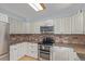 Well-lit kitchen featuring white cabinets, granite countertops, stainless steel appliances, and light wood flooring at 1313 Garden Cir, Longmont, CO 80501