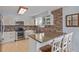 Bright kitchen with white cabinets, brick backsplash, stainless steel appliances, and granite countertops with seating at 1313 Garden Cir, Longmont, CO 80501