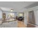 Open kitchen with white cabinets, stainless steel refrigerator, granite countertops, and view to dining and living areas at 1313 Garden Cir, Longmont, CO 80501