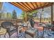 Inviting covered deck, ideal for outdoor gatherings, featuring wicker furniture, grill, and relaxing backyard views at 4845 S Taft St, Morrison, CO 80465