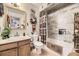 Charming bathroom featuring tiled shower over tub, wood vanity, framed mirror and western decor at 4845 S Taft St, Morrison, CO 80465