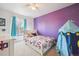 Bright bedroom featuring a purple accent wall, starry decor, and cozy furnishings at 3660 S Ouray Cir, Aurora, CO 80013