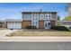 Two-story home with brick and gray siding, featuring a well-manicured front yard and an attached two car garage at 3660 S Ouray Cir, Aurora, CO 80013