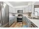 Modern kitchen features gray cabinets, stainless steel appliances, a white backsplash and wood look flooring at 3660 S Ouray Cir, Aurora, CO 80013