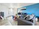 Bright living room with blue accent wall, gray sofa, and patterned rug creating a cozy and inviting space at 3660 S Ouray Cir, Aurora, CO 80013