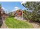 Spacious backyard featuring vibrant green grass and mature trees offering shade and character at 464 N Jamestown Way, Aurora, CO 80018