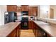 A kitchen featuring wood cabinets, black appliances and an island, ideal for modern cooking at 464 N Jamestown Way, Aurora, CO 80018